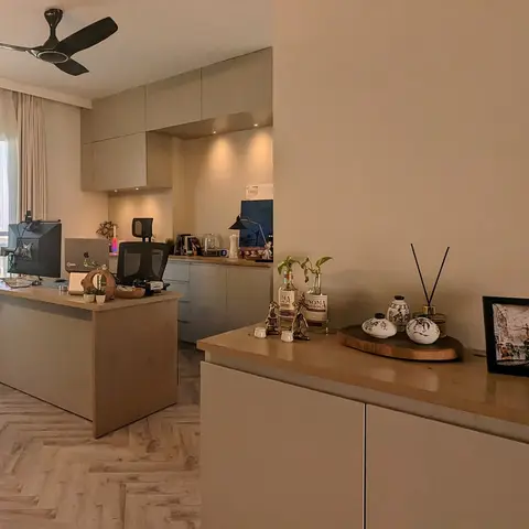 Open-plan work corner with a built-in study desk and ergonomic chair on a herringbone wood floor