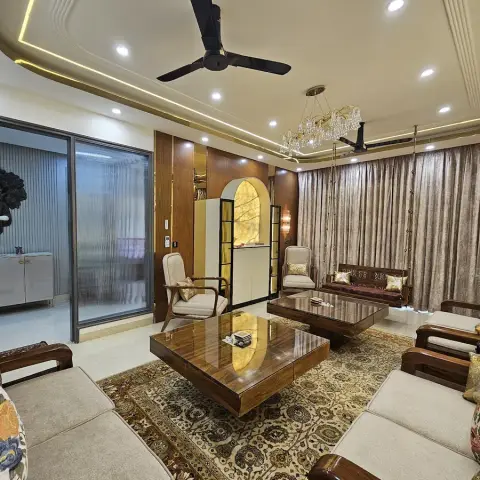 Opulent living room with a crystal chandelier over a carved wood sofa set on a Persian-style rug, a wall-mounted Buddha art piece