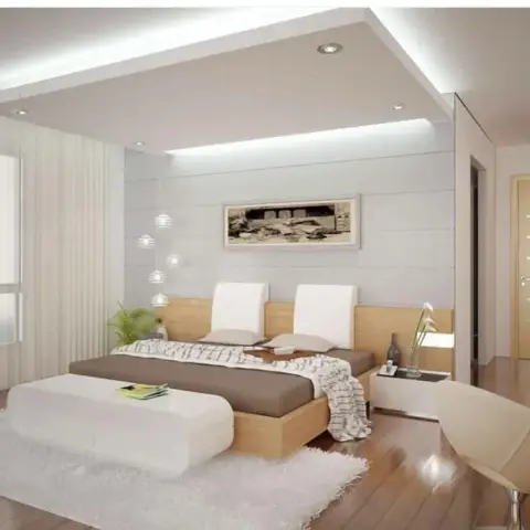 Pale bedroom render with a light-oak platform bed and full-width headboard under a stepped cove-lit false ceiling