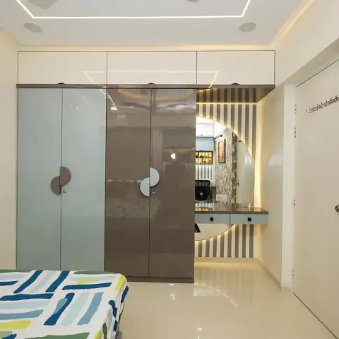 Photo of a bedroom with a four-door high-gloss wardrobe in grey-blue and bronze with half-moon handles