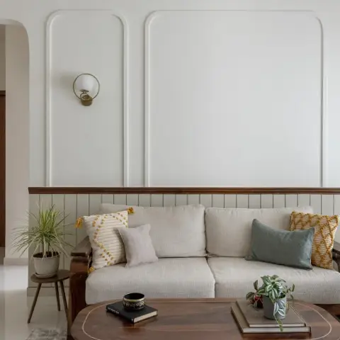 Photo of a living room where three rounded-corner wall moulding bays sit above a sage fluted dado capped with a dark wood chair rail