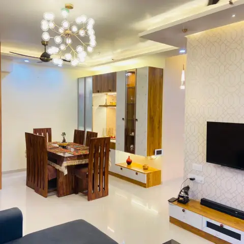 Photo of an open living-dining in a flat: a sheesham six-seater under a brass sputnik chandelier, a veneer-and-marble crockery unit behind it