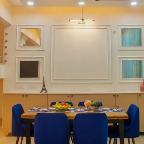 Photograph of a dining room with six royal-blue velvet chairs around a wooden table