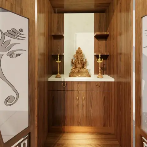 Pooja niche lined in teak veneer with a brass Ganesha on a white marble platform between two corner shelves and a pair of standing lamps