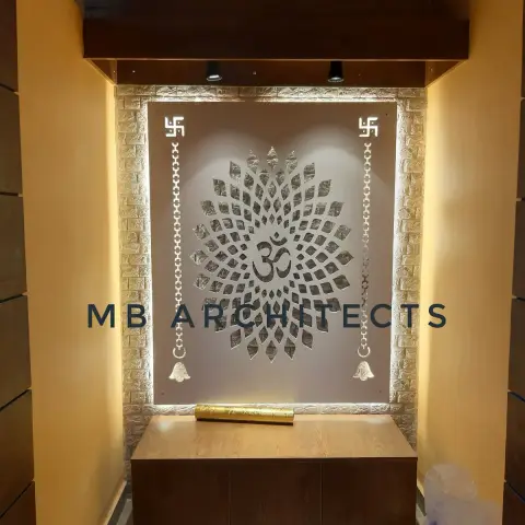 Pooja niche with a backlit carved Om medallion jaali panel flanked by swastik motifs and hanging bell decorations