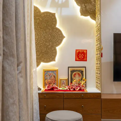 Pooja niche with CNC-cut gold mandalas backlit against a white panel, a jaali screen down one side