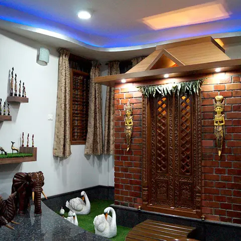 Pooja room with an exposed-brick temple facade and carved wood doors, cove-lit in blue