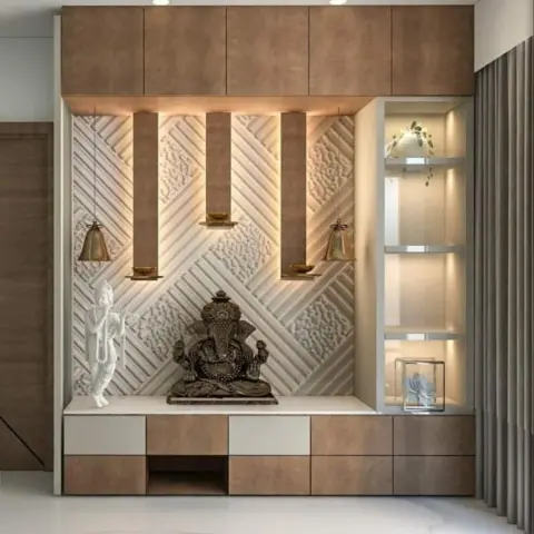 Pooja unit with a textured diamond-pattern backwall, brass hanging bells flanking a Ganesha idol, and wood cabinetry with lower storage drawers.