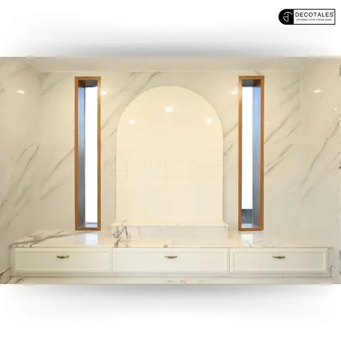 Pooja unit with an arched marble niche flanked by vertical LED light strips in wood trim, set above a marble-topped cabinet with brass-handled drawers.