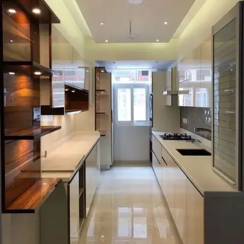 Real galley-style kitchen with a dark wood-veneer floating display shelf unit, glossy white cabinetry, a cove ceiling with downlights