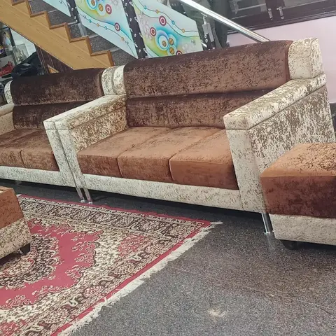 Real living room with a brown and cream crackle-velvet sofa set and matching ottomans on a red oriental-pattern rug