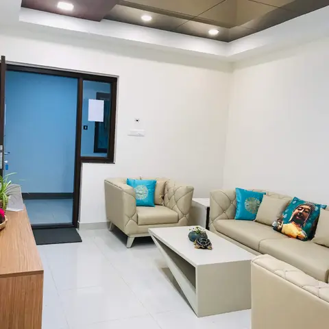 Real living room with a cream tufted leather sofa set, teal accent cushions including a Buddha print