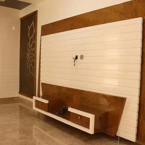 Real living room with a rust-textured stone TV feature wall bordering a white grooved panel insert, a floating two-tone TV unit