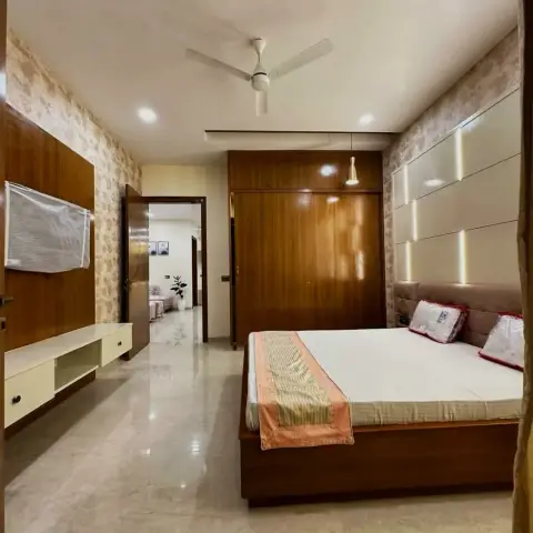 Real photo of a bedroom with a floral-wallpaper wall, a dark wood-veneer wardrobe wall, a floating TV console with the television still in its plastic wrap
