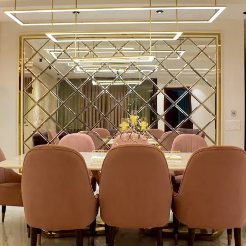 Real photo of a dining room with blush-pink velvet channel-tufted chairs around an oval marble table