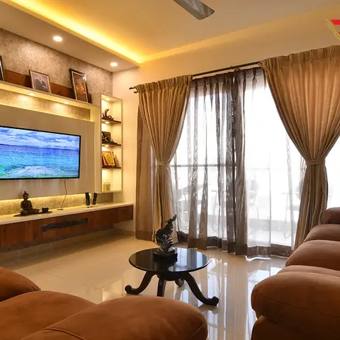 Real photo of a living room with brown leather sofas, a floating TV console under a backlit textured feature wall styled with framed art
