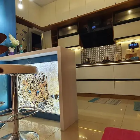 Real photo of an open kitchen with glossy white handleless cabinets and a mosaic-tile backsplash