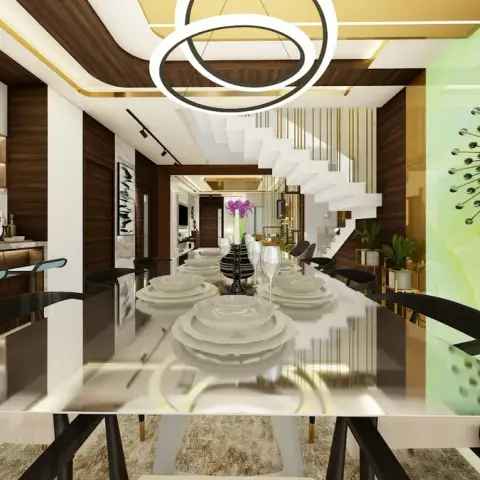Render looking down a long white-stone dining table set with stacked plates and glassware, twin ring pendants overhead