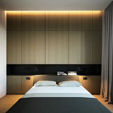 Render of a bedroom with a floor-to-ceiling walnut-panelled headboard wall, a backlit cove, a built-in black reading-light niche