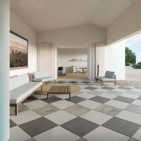 Render of a covered home veranda with a grey-and-cream checkerboard tile floor, a low wooden bench and armchairs around a round rug