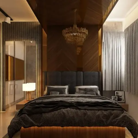 Render of a dark bedroom where a chevron walnut wall rises behind a charcoal channel headboard under a brass crystal chandelier