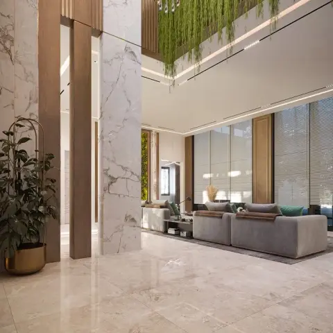 Render of a double-height entrance lobby with marble-clad columns, a hanging greenery installation along the upper wall, a crystal chandelier