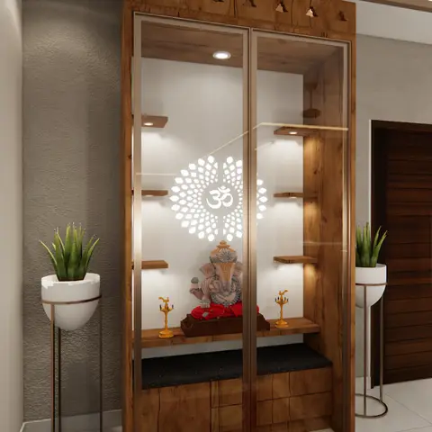 Render of a glass-fronted wood pooja unit with a backlit Om motif and idol niche, flanked by potted plants near the entrance door with the kitchen visible