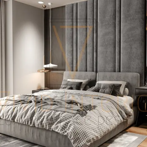 Render of a grey moody bedroom with a floor-to-ceiling channel-tufted fabric headboard wall, a brass pendant light, and an attached study desk in the corner.