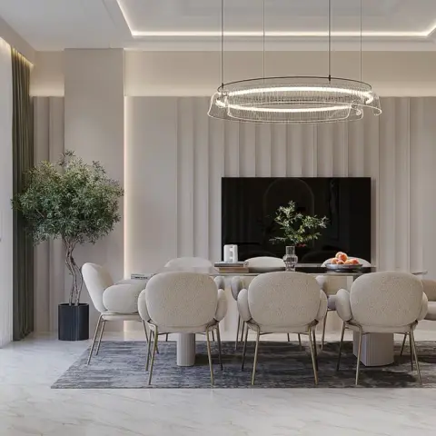 Render of a large dining room where eight bouclé chairs on brass legs surround an oval table on a grey rug, under a wide crystal ring chandelier