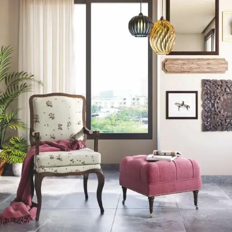 Render of a living-room corner with a floral French armchair and a dusty-pink tufted ottoman on castors