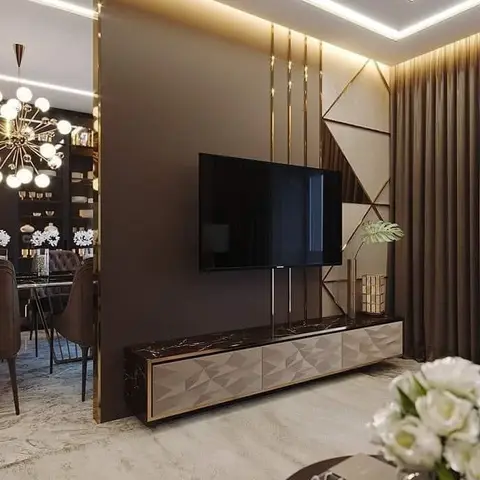 Render of a living room TV feature wall with gold linear inlays on a faceted taupe panel, a dark marble-and-diamond-textured TV console, and a brown curtain