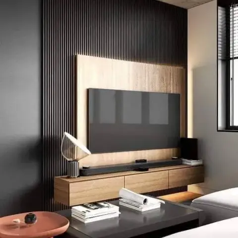 Render of a living-room TV wall in tightly pitched black fluted slats with a backlit oak veneer inset, a floating oak console
