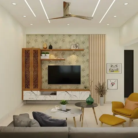 Render of a living room TV wall with floral wallpaper, a marble-effect base unit, and a mustard-yellow accent armchair beside a grey sofa.