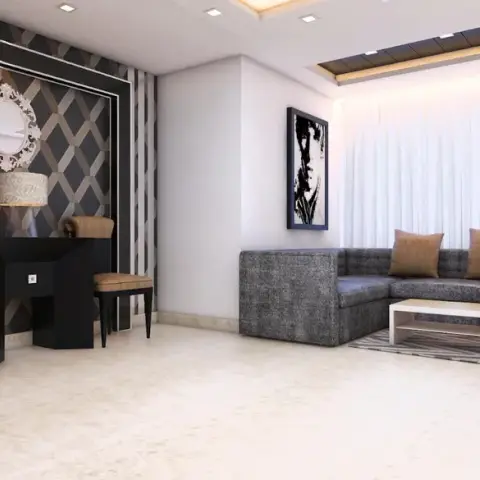 Render of a living room where a charcoal tweed L-sofa faces a bronze-and-charcoal interlocking-diamond feature wall holding an ornate white oval mirror over a