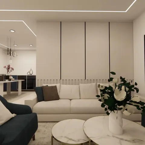 Render of a living room with a cream sofa and navy accent armchairs around round marble nesting coffee tables