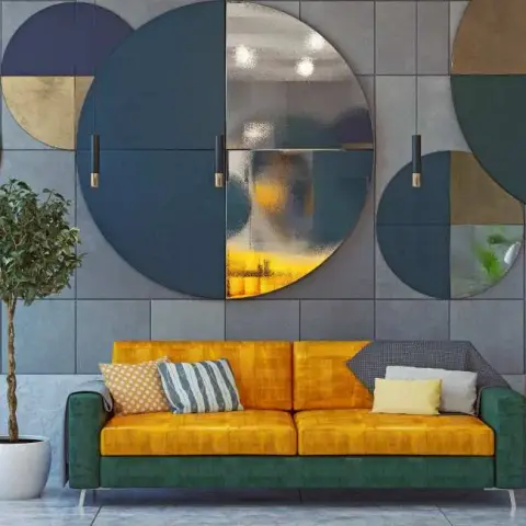 Render of a living room with a mustard and green velvet sofa beneath a cluster of oversized circular mirror and panel wall art in teal, brass and grey.