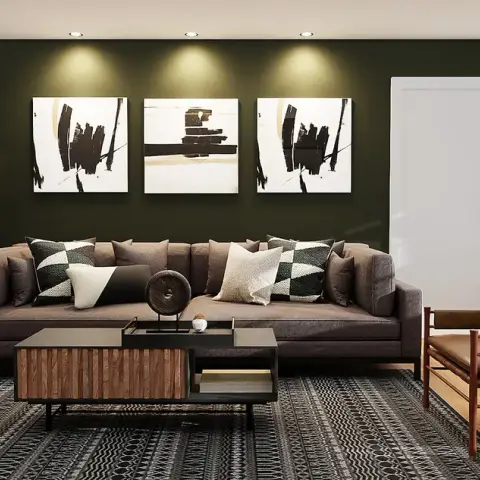 Render of a living room with an olive-green accent wall, black-and-white triptych art, a brown sectional sofa with graphic cushions