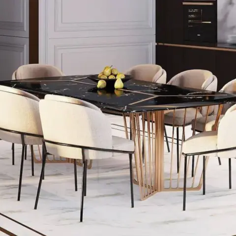 Render of a luxury dining room with a black marble table on a gold spoke pedestal base and cream upholstered chairs, opening into a dark wood modular kitchen.