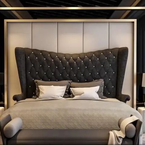 Render of a master bedroom with a tufted charcoal wingback headboard framed in a gold panel surround, flanked by matching nightstands.