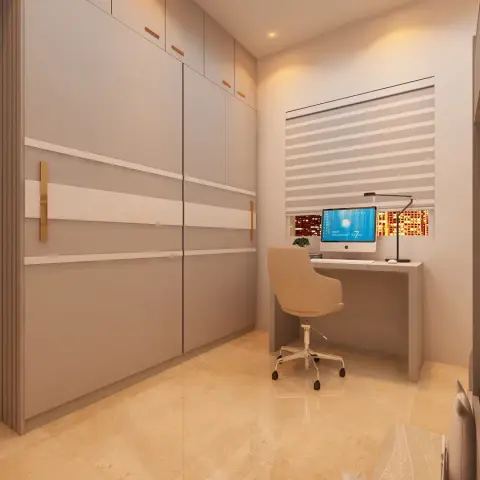 Render of a narrow bedroom where a greige wardrobe wall with inset white bands and slim brass pull handles faces a matching study table with an iMac and black