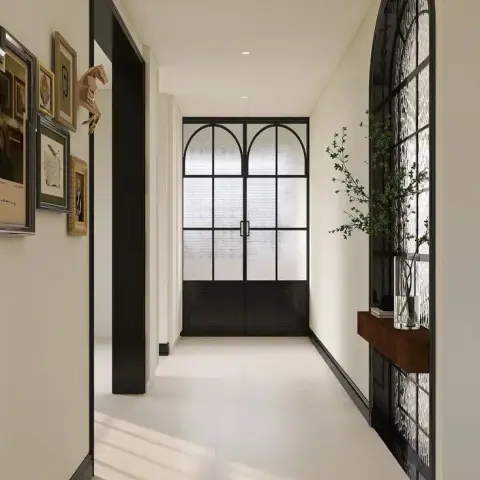 Render of a narrow entry hall lined with a salon-hung gallery wall, ending in black steel arched doors glazed in fluted glass
