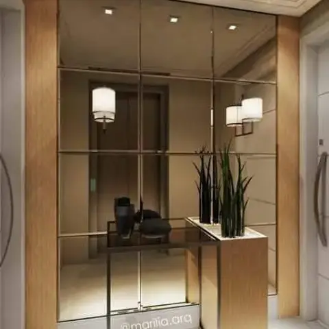 Render of an entrance foyer with a full-height mirrored panel wall framed in wood battens, wall sconces, a glass console table