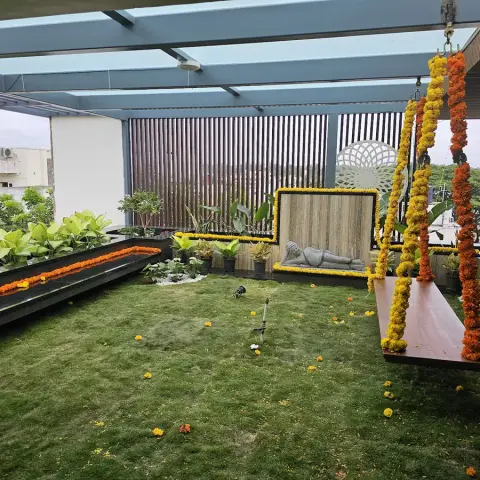 Rooftop terrace under a steel-and-polycarbonate pergola with a lawn, granite-edged planter beds