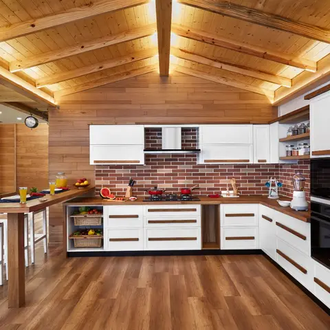 Rustic kitchen with a vaulted wood-beamed ceiling, red brick backsplash, white shaker-style cabinets with wood pull handles