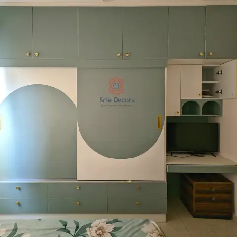 Sage-green sliding wardrobe with a sculptural two-tone circular cutout design and gold hardware