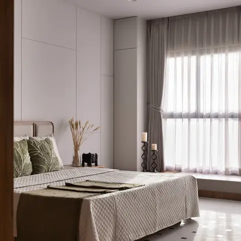 Serene bedroom with olive-green textured cushions and throw against a quilted ivory bedspread, floor-to-ceiling panelled wardrobe wall
