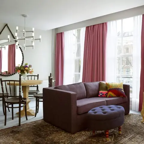 Sitting room with dusty-rose floor-length drapes over white sheers along a full window wall