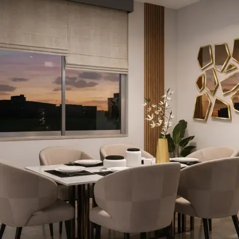 Six beige velvet tub chairs around a white marble-top dining table at dusk, under a cluster of irregular gold-framed faceted mirrors