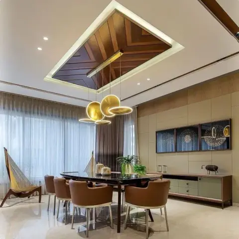 Six-seater black glass dining table under a mitred wood-inlay ceiling raft and a cluster of three gold disc pendants