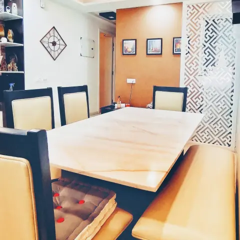 Six-seater dining set with a cream onyx-veined stone top, black-framed leather chairs and a matching bench